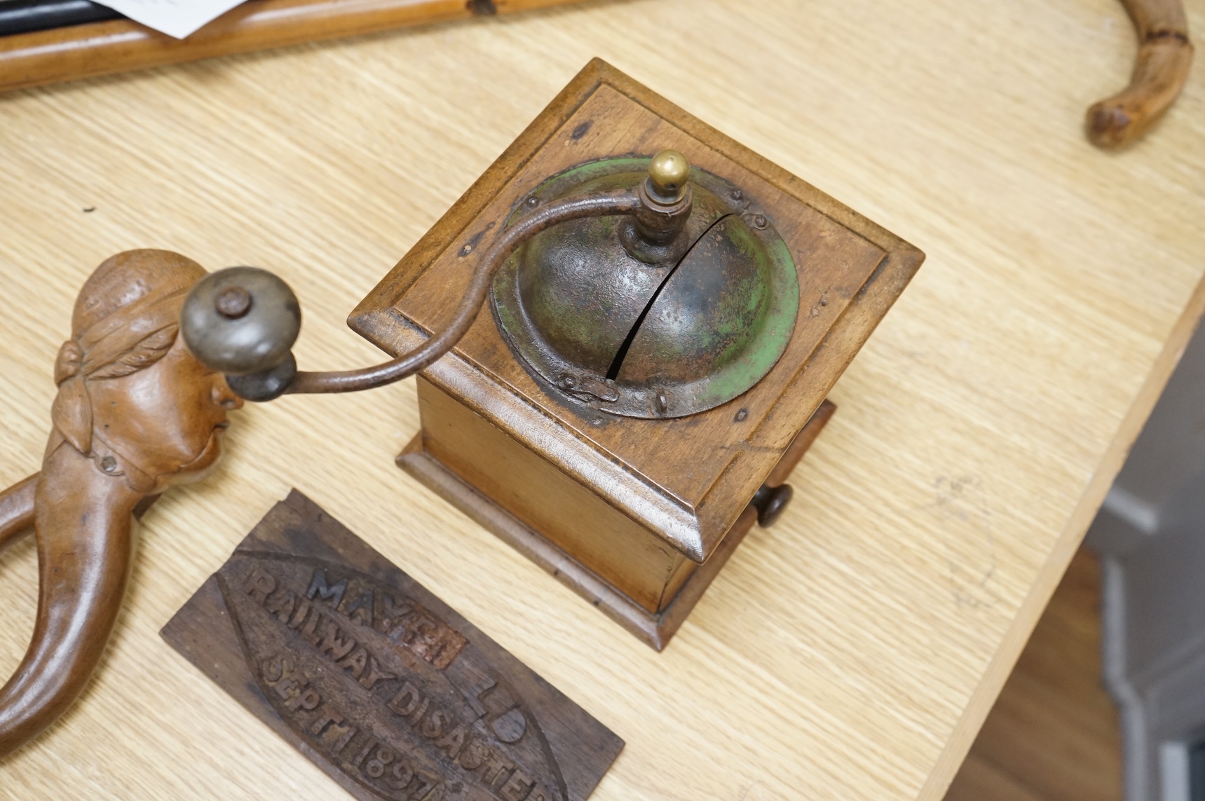 A coffee grinder, a figural nut cracker, two walking sticks, one mother of pearl inlaid and a railway sign